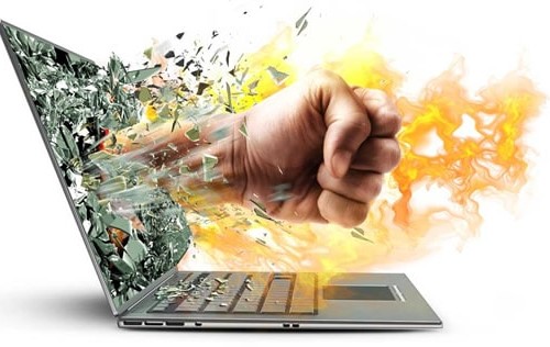 A hand punching through a laptop